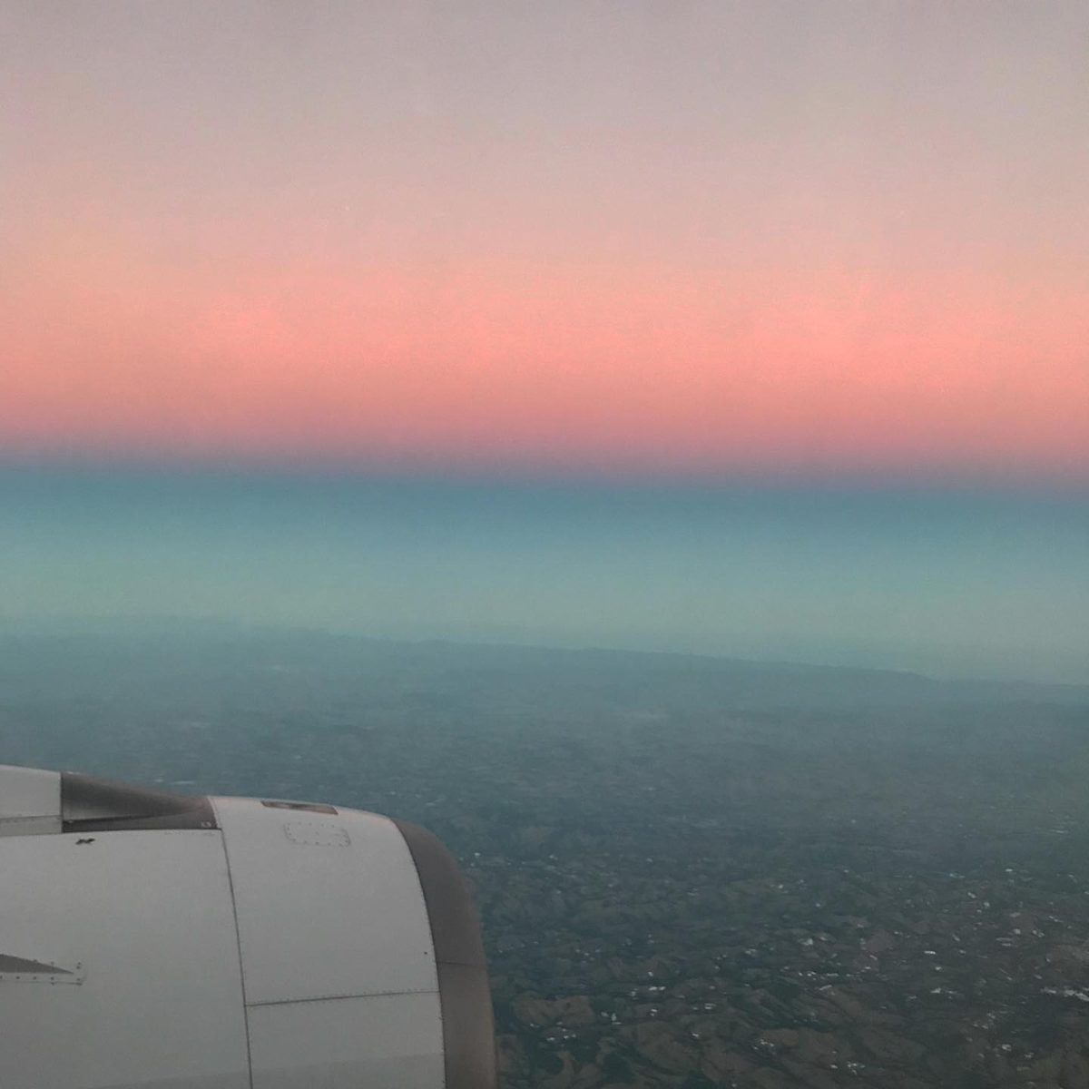 Céu rosa pela janela do avião