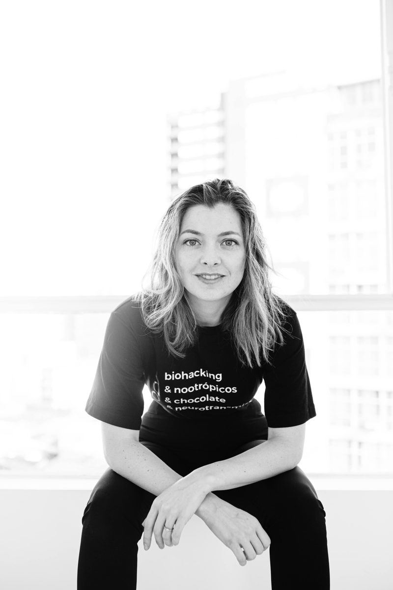 Camila em estúdio com camiseta biohacking e nootrópicos